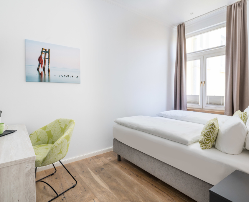 Doppelzimmer im Parkhotel Wangerooge mit hellem Interieur, Schreibtisch, Flachbild-TV, maritimem Wandbild und großem Fenster
