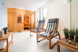 Saunabereich im Parkhotel Wangerooge mit Holzsauna, Ruhestühlen und Holzbank mit eingerollten Handtüchern